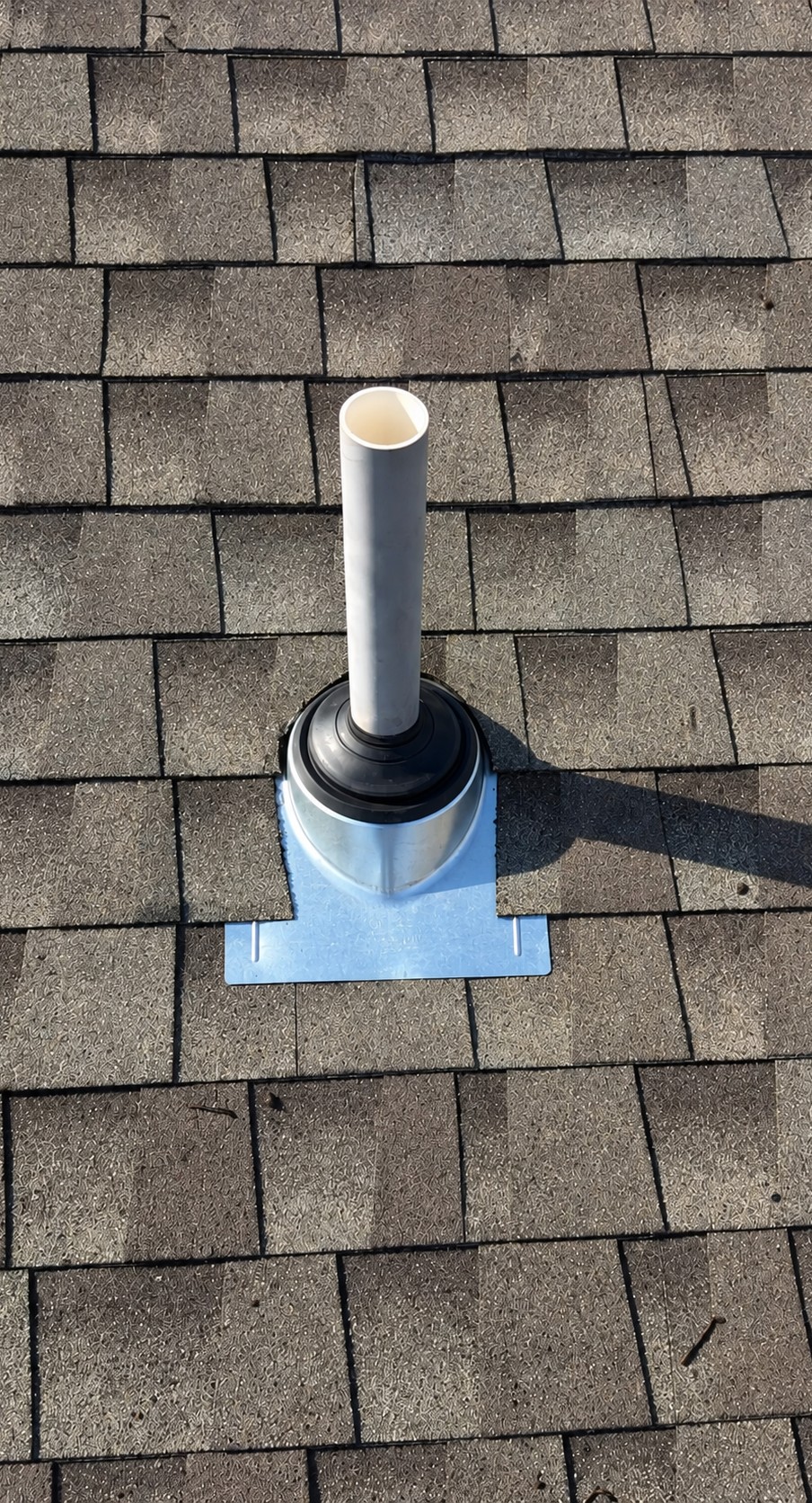 Close-up of new pipe boot flashing sealed into shingles