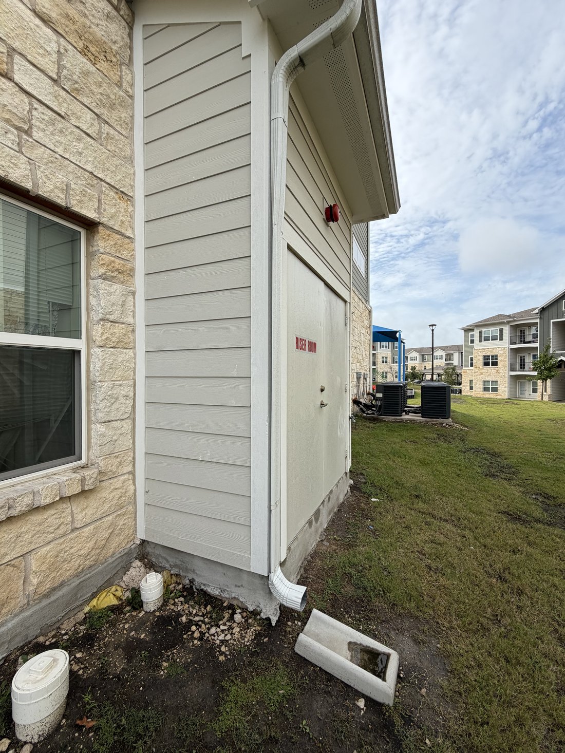 Side view of downspout flattened by a riser room door blown open in the wind