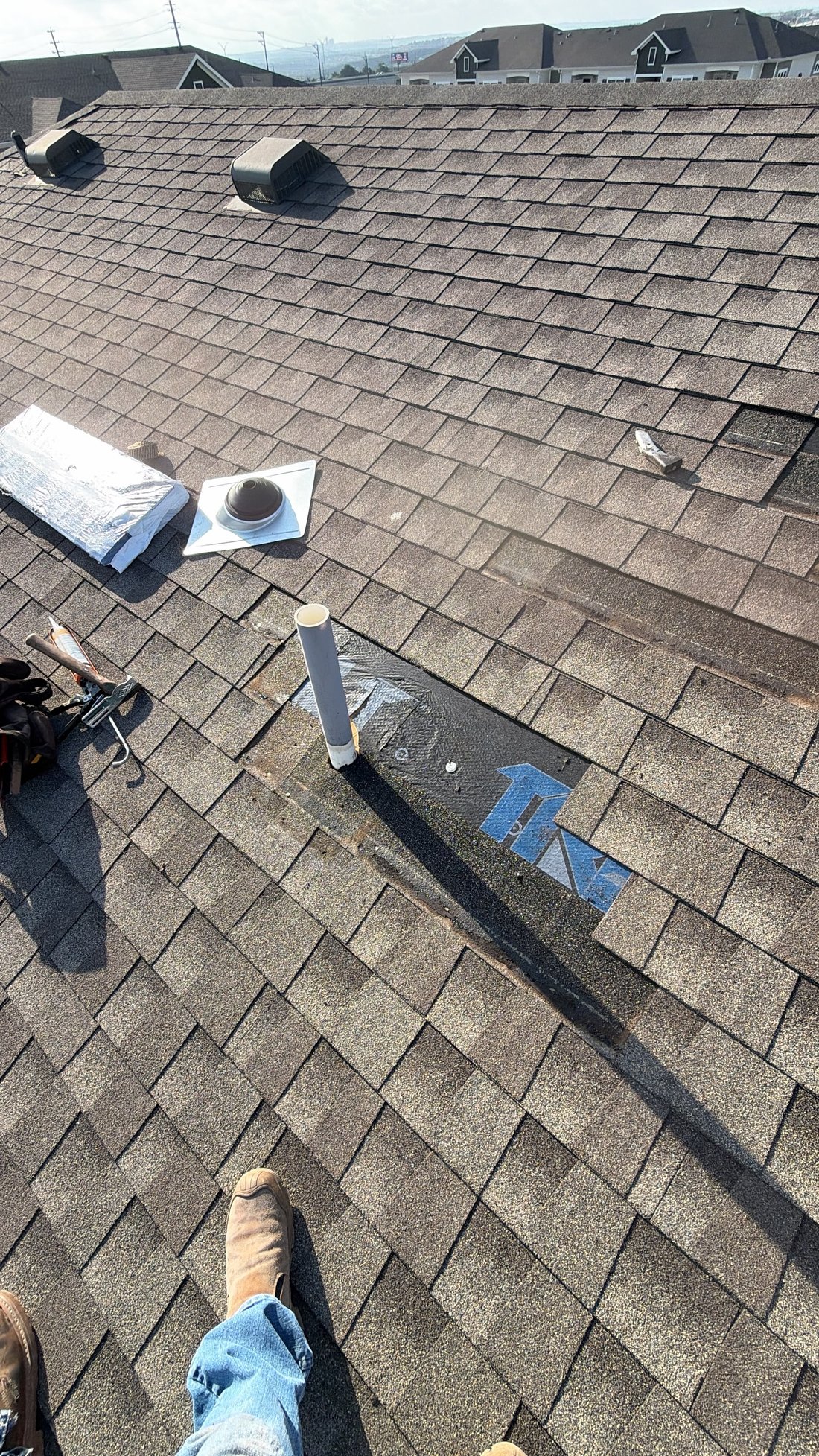 Shingles pulled back with new pipe boot ready to set