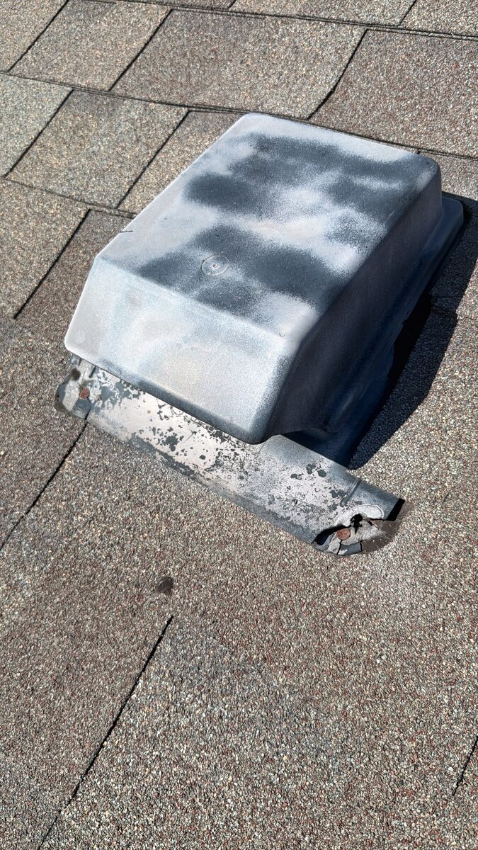Larger weathered plastic roof vent with broken, punctured flange and exposed rusted nails