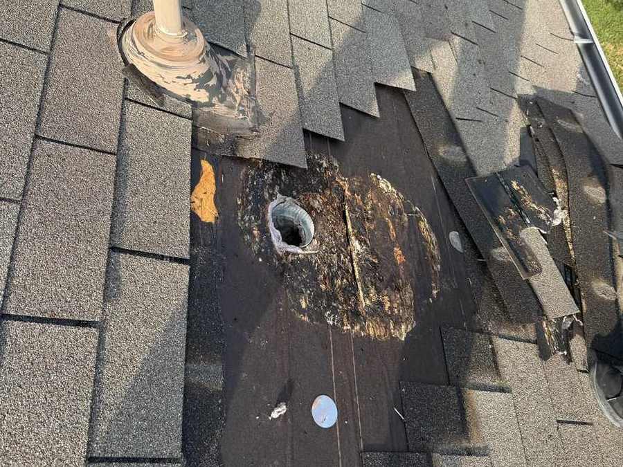 Rot at a roof vent, shingles pulled back.