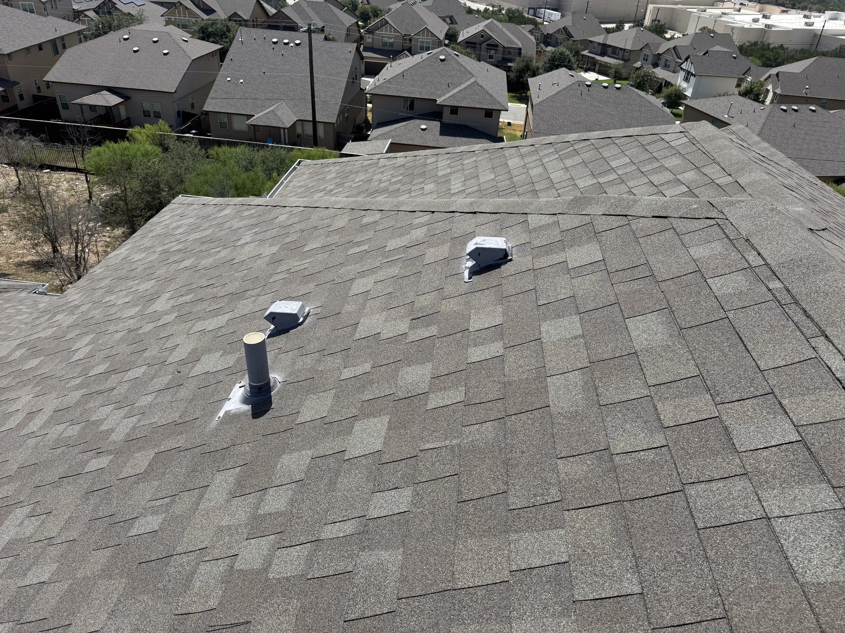 Pipe boot flashings and gooseneck static vents on a multifamily roof