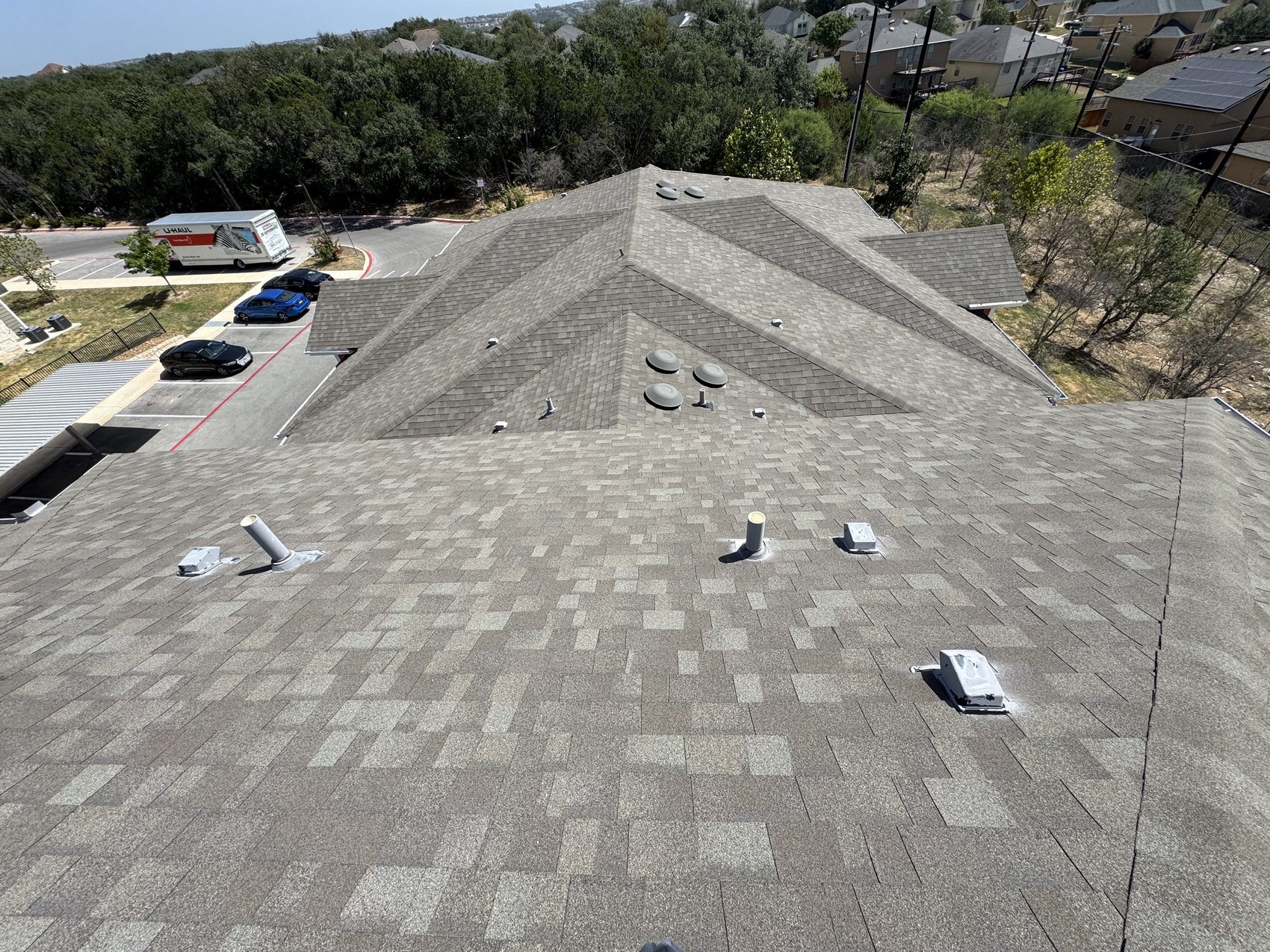 Multifamily roof walk over lower slopes with vents and pipe stacks