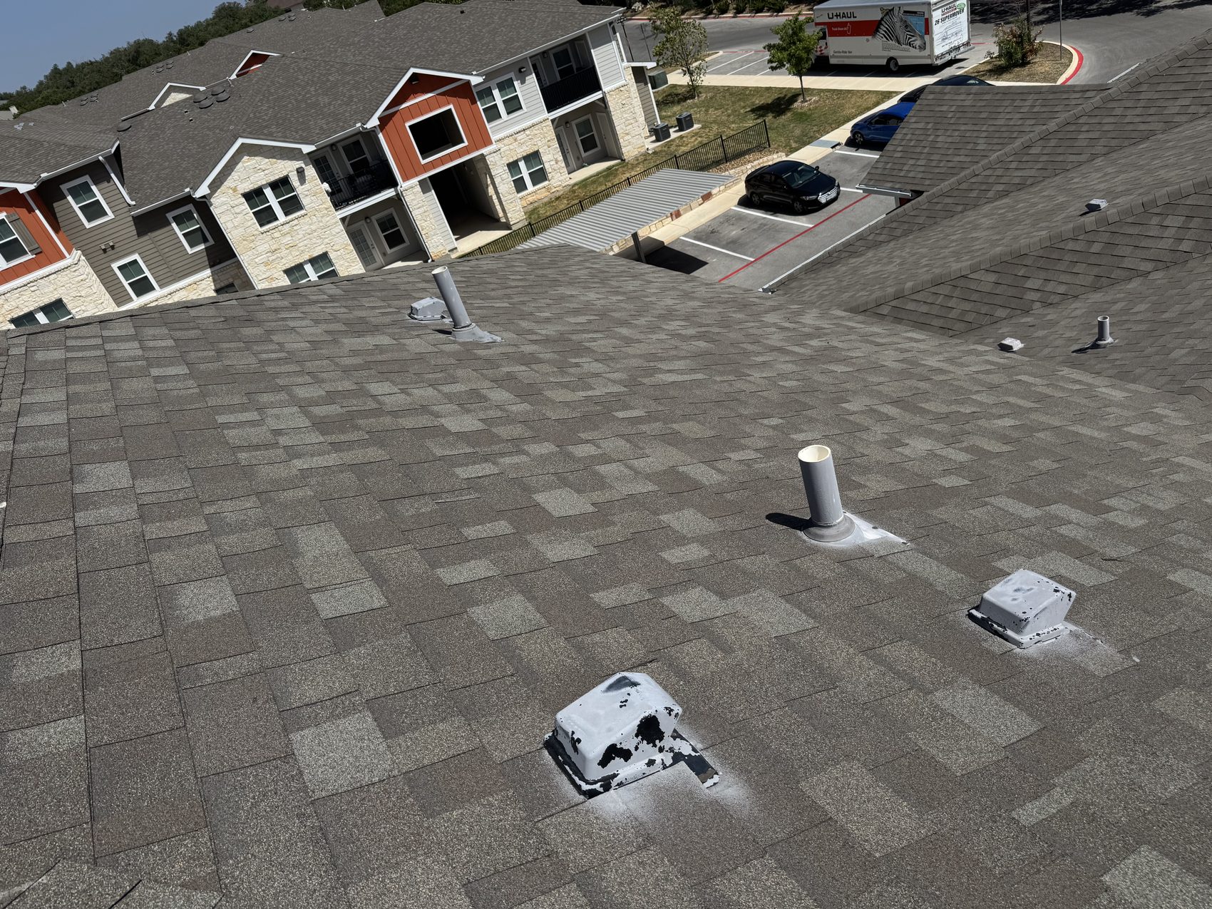 Pipe boot flashings and gooseneck static vents on a multifamily roof